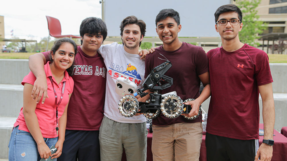五名学生手持机器人。