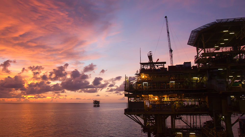 海面上的石油平台，背景是夕阳。